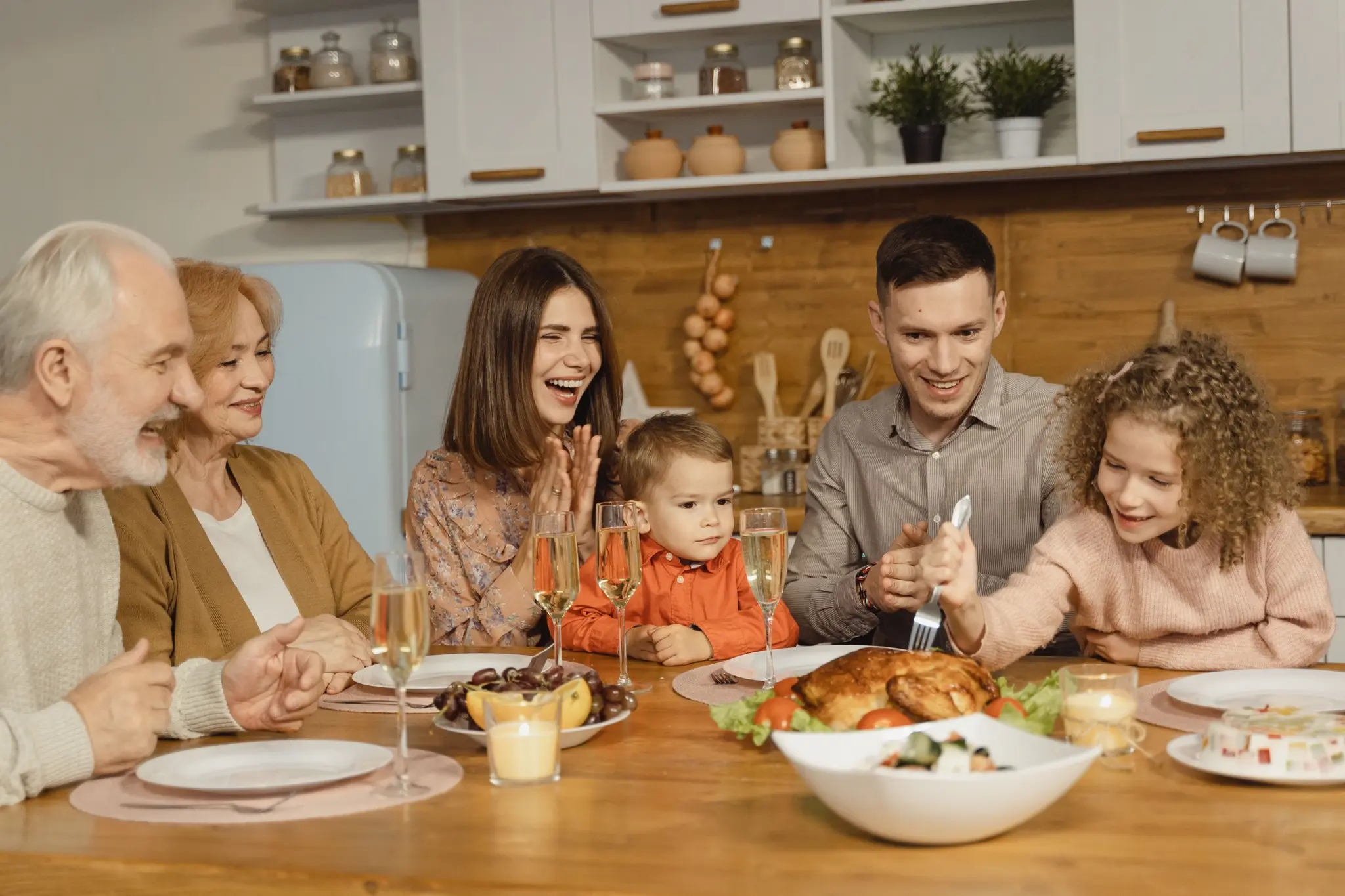 Una familia ríe junta alrededor de la mesa en una cena de fiesta